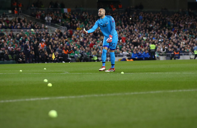 Darren Randolph removes tennis balls from the field