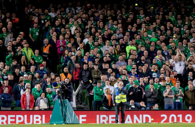 Fans throw tennis balls onto the pitch