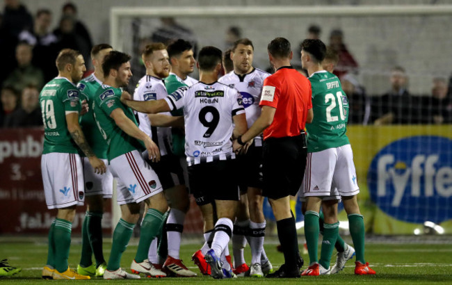 Paul McLoughlin surrounded by players from both teams