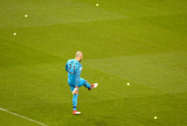 Darren Randolph removes tennis balls from the pitch after fans protest John Delaney