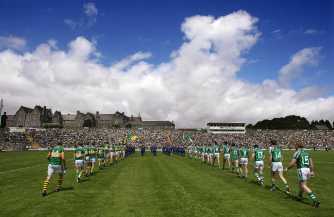 The Kerry and Limerick players walk behind the band