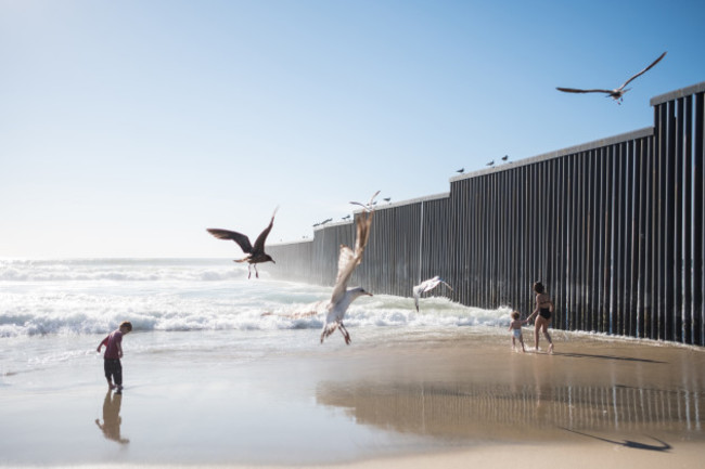 Migrants crossing the US-Mexico border wall in Tijuana, Mexico - 13 Mar 2019