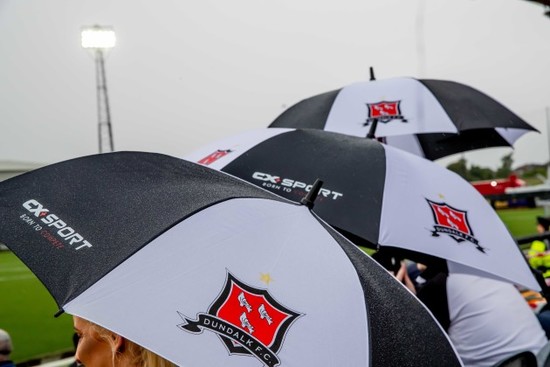 Dundalk fans shelter from the rain before the game