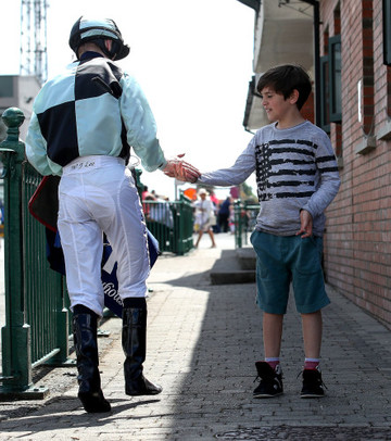 Jockey James Lee high fives a young fan after winning the Irish Stallion Farms EBF Maiden