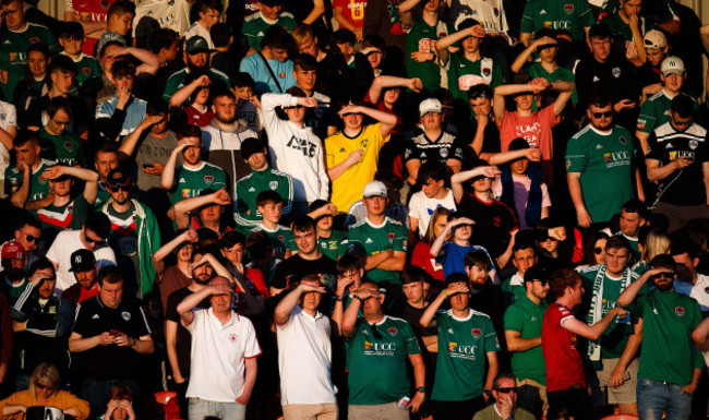 Fans shield their eyes from the sun