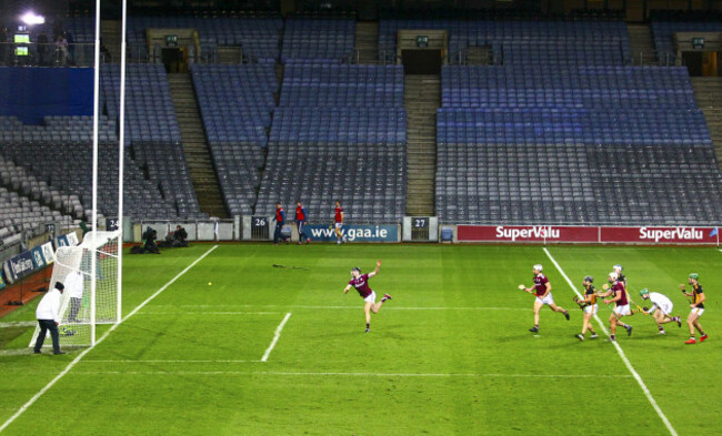 joseph-cooney-throws-a-hurl-as-richie-hogan-scores-a-goal