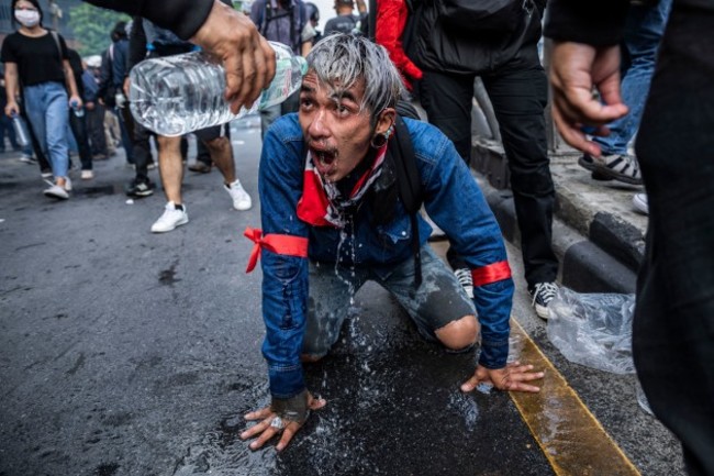 bangkok-thailand-7th-aug-2021-pro-democracy-protestors-flush-tear-gas-out-of-the-eyes-of-another-protestor-during-clashes-with-police-pro-democracy-protestors-attempted-to-march-from-victory-monu