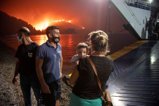 people-board-a-ferry-during-evacuation-as-a-wildfire-burns-in-the-village-of-limni-on-the-island-of-evia-greece-august-6-2021-picture-taken-august-6-2021-reutersnicolas-economou