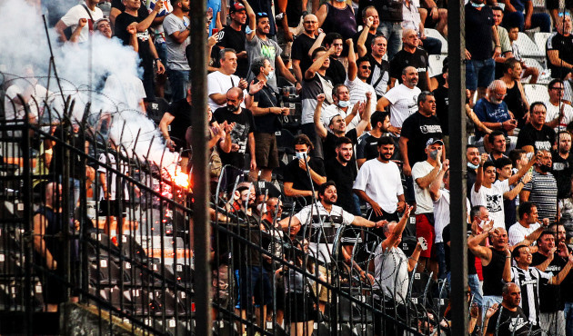 paok-fans-light-a-flare-in-the-stands-at-the-game