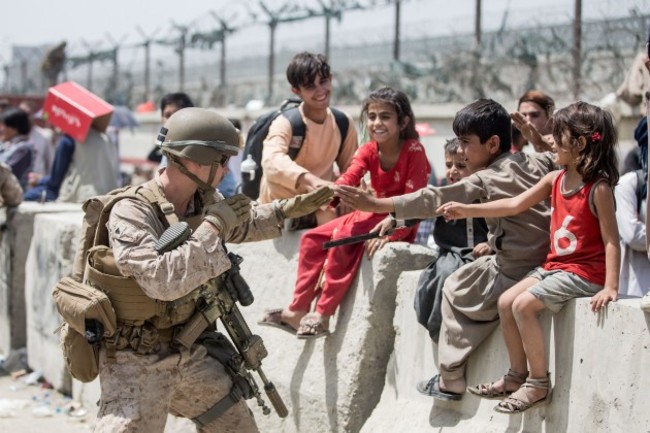 kabul-afghanistan-20th-aug-2021-a-marine-with-special-purpose-marine-air-ground-task-force-crisis-response-central-command-spmagtf-cr-cc-plays-with-children-waiting-to-process-during-an-evacuati