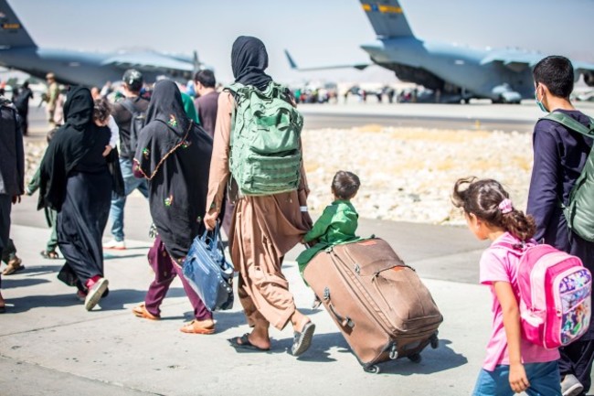 a-child-looks-at-the-aircraft-as-he-is-strolled-towards-his-flight-during-an-evacuation-at-hamid-karzai-international-airport-kabul-afghanistan-aug-24-u-s-service-members-are-assisting-the-depar