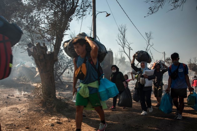 migrant-families-carry-their-belongings-to-flee-flames-that-broke-out-in-the-moria-migrants-camp-thousands-of-people-have-been-forced-to-flee-their-homes-after-a-fire-broke-out-in-moria-camp-destroyin