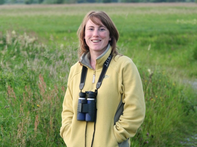 Kathryn Finney of BirdWatch Ireland wearing a yellow fleece standing in a field