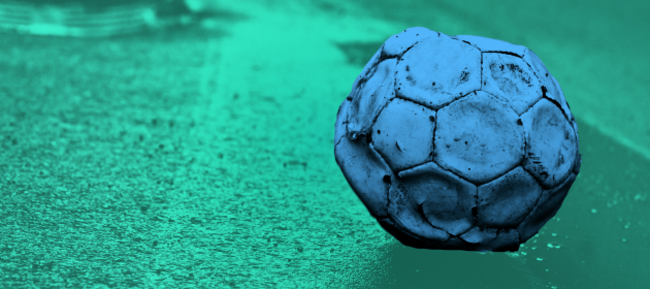 Design for Tough Start project - An old football that has too little air in it sitting on the side of the road.