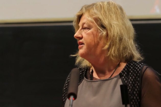 Dr Margaret Fitzgerald wearing a light grey top standing talking at a podium