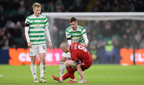 aberdeens-scott-brown-is-helped-up-by-celtics-josip-juranovic-during-the-cinch-premiership-match-at-celtic-park-glasgow-picture-date-sunday-november-28-2021