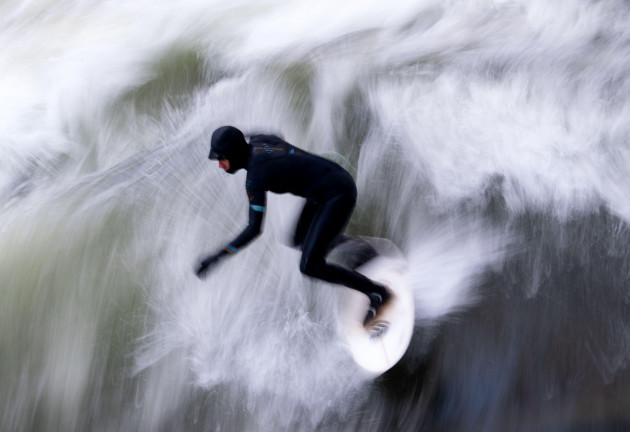 munich-germany-03rd-dec-2021-a-man-rides-the-eisbach-wave-in-the-english-garden-the-artificial-wave-is-considered-a-popular-hotspot-for-surfers-and-spectators-all-year-round-credit-sven-hopped