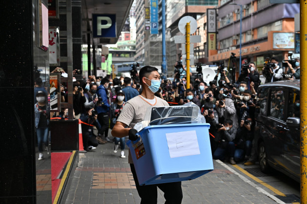 lam-tin-china-29th-dec-2021-a-police-officer-carries-the-news-materials-and-evidence-in-blue-plastic-boxes-after-searching-the-office-of-stand-news-amid-the-political-suppression-hong-kong-indepe