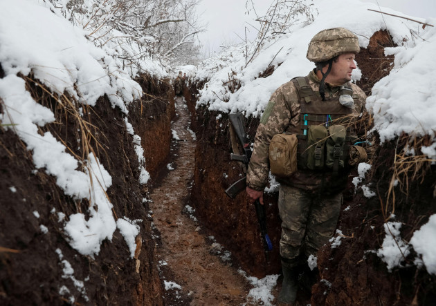a-ukrainian-service-member-stands-in-a-trench-on-the-front-line-near-the-village-of-zaitseve-in-the-donetsk-region-ukraine-december-18-2021-reutersgleb-garanich