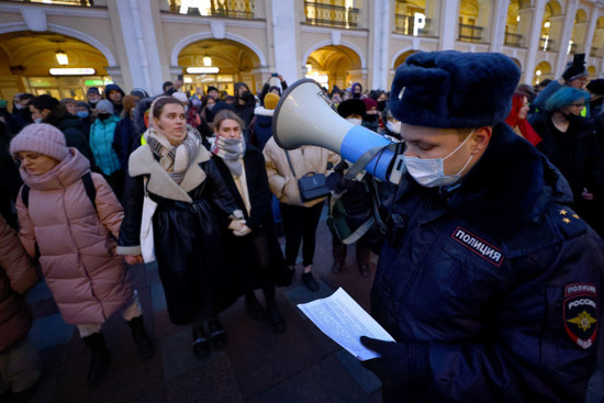 st-petersburg-russia-24th-feb-2022-a-police-officer-with-a-megaphone-and-demonstrators-are-seen-during-an-unsanctioned-anti-war-protest-in-central-st-petersburg-early-on-24-february-russias-pre