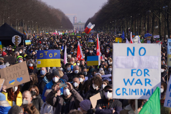 berlin-germany-27th-feb-2022-people-hold-flags-signs-and-placards-during-a-demonstration-under-the-slogan-stop-the-war-peace-for-ukraine-and-all-europe-against-the-russian-attack-on-ukraine