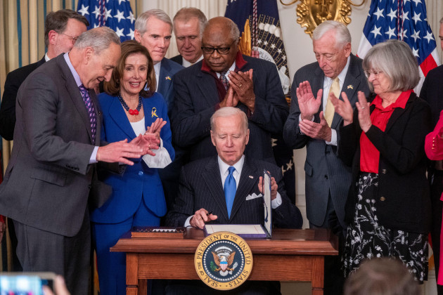 united-states-president-joe-biden-signs-h-r-3076-the-postal-service-reform-act-of-2022-during-a-ceremony-in-the-state-dining-room-of-the-white-house-in-washington-dc-usa-06-april-2022-looking-on