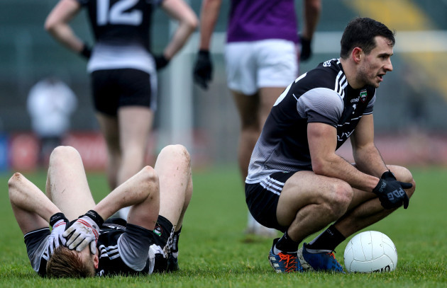 niall-murphy-sits-on-the-ball-whilst-conor-griffin-is-injured