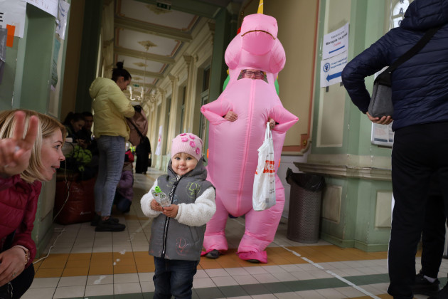 przemysl-poland-17th-apr-2022-a-woman-shows-her-daughter-to-make-a-peace-sign-at-the-przemysl-poland-train-station-on-easter-sunday-near-the-border-of-ukraine-after-a-pink-unicorn-gives-her-can