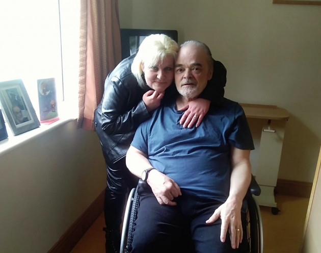 Michelle Murray hugging husband Charles who is sitting in a wheelchair.