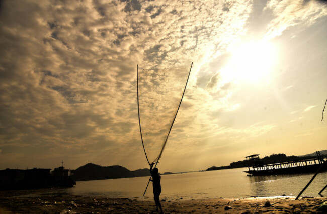 may-5-2022-guwahati-guwahati-india-a-man-carry-fishing-net-in-river-brahmaputra-to-catch-fishes-which-flows-from-chinas-tibet-and-enter-india-through-arunachal-pradesh-in-guwahati-assam-india-o