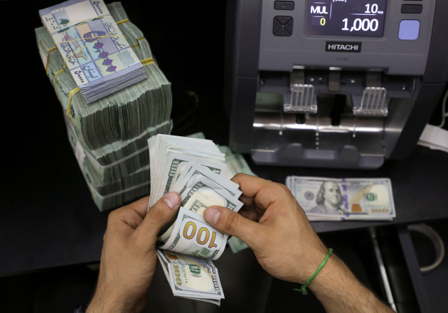 a-money-exchange-vendor-counts-u-s-dollar-banknotes-next-to-lebanese-pounds-at-a-currency-exchange-shop-in-beirut-lebanon-may-24-2022-picture-taken-may-24-2022-reutersmohamed-azakir