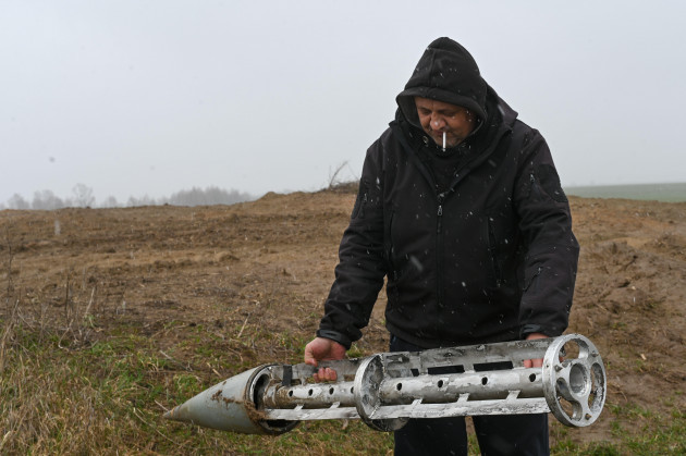 ukraine-03rd-apr-2022-a-ukrainian-civilian-gennadiy-removes-a-russian-cluster-munition-rocket-from-a-field-near-the-villages-of-smolyanka-and-olyshivka-after-shelling-in-the-previous-nights-in-the