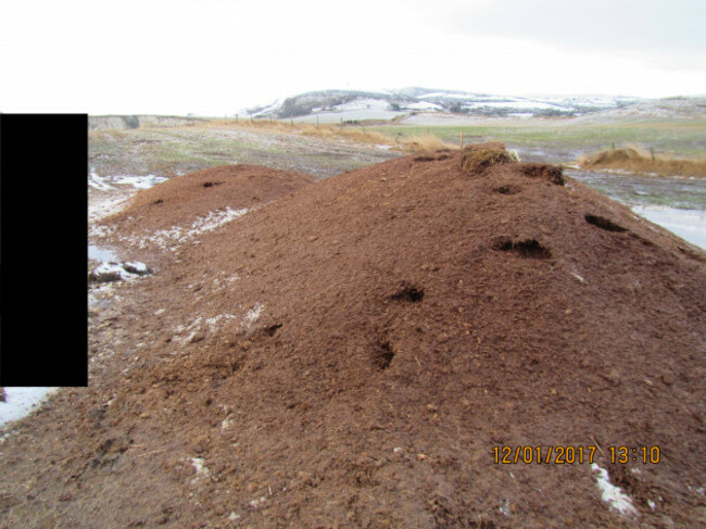 A large mound of poultry manure left in a field