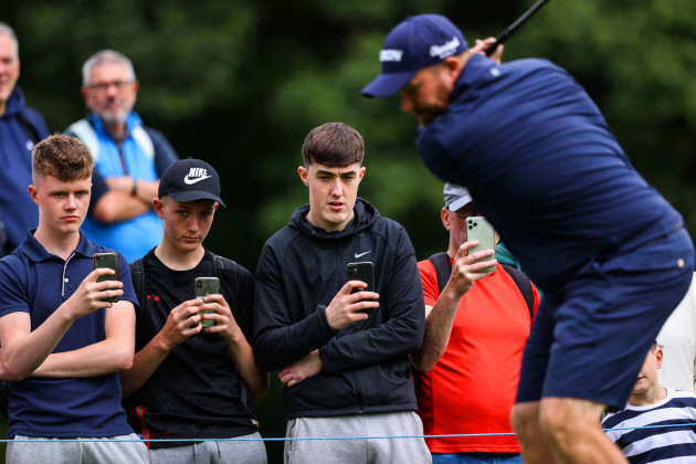 members-of-the-crowd-film-as-shane-lowry-tees-off-on-the-eighth