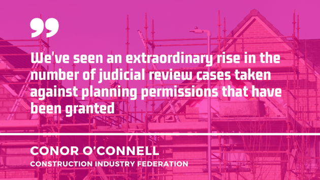 Houses under construction with quote in front from Conor O'Connell from the Construction Industry Federation - We've seen an extraordinary rise in the number of judicial review cases taken against planning permissions that have been granted