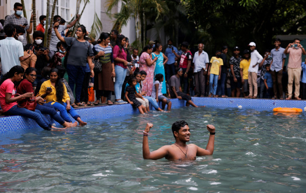 a-man-stands-in-the-swimming-pool-as-people-visit-the-presidents-house-on-the-day-after-demonstrators-entered-the-building-after-president-gotabaya-rajapaksa-fled-amid-the-countrys-economic-crisis