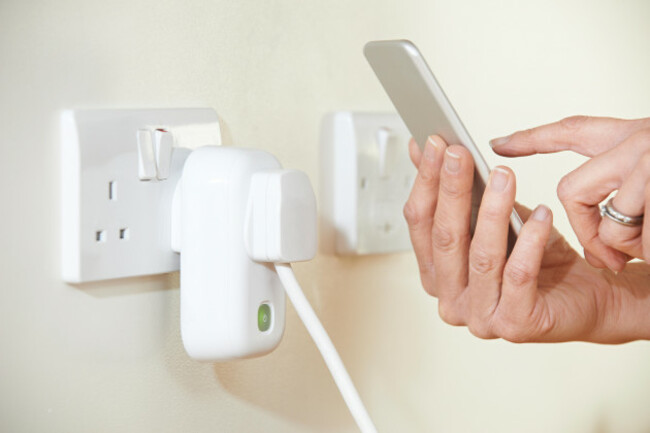 woman-controlling-smart-plug-using-app-on-mobile-phone