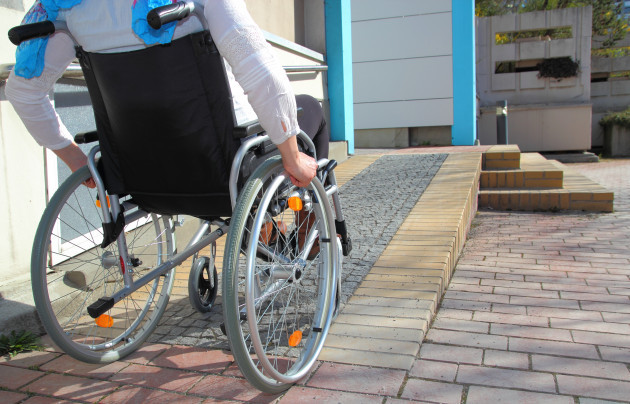 Wheelchair user on a ramp leading up to a house