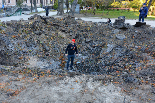 kyiv-ukraine-11th-oct-2022-people-seen-near-the-funnel-from-the-explosion-of-a-russian-rocket-on-a-childrens-playground-in-the-center-of-the-capital-after-several-months-of-relative-calm-multip