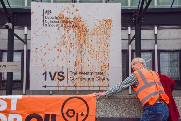 london-england-uk-17th-oct-2022-a-protester-stands-with-his-hand-glued-next-to-the-soup-covered-beis-entrance-sign-just-stop-oil-threw-soup-and-glued-themselves-outside-beis-department-for-busi