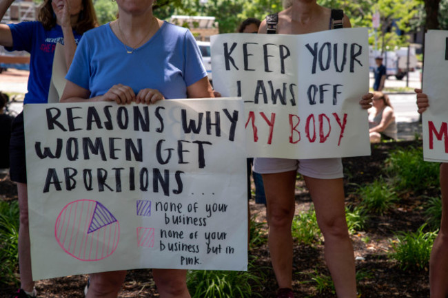 women-hold-pro-choice-protest-signs-at-a-political-rally