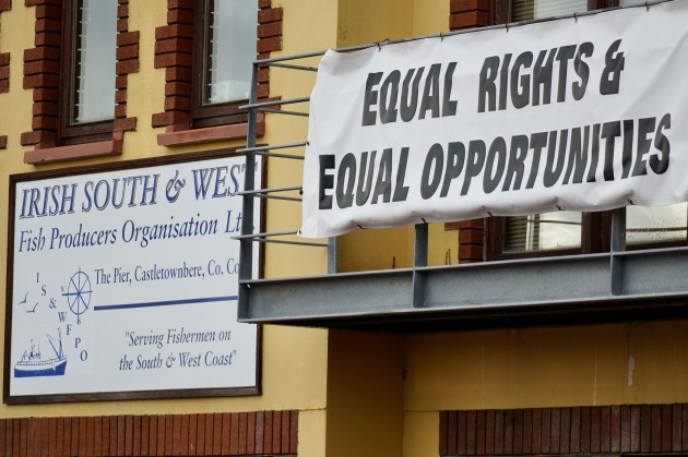 Building with a sign - Irish South & West Fish Producers Organisation Ltd - The Pier, Castletownbere, Co Cork - with the slogan: Serving Fishermen on the South & West Coast. Another sign on a balcony says: Equal Rights & Equal Opportunities.