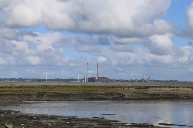 View of a power station in the distance from a beach 