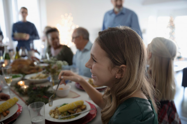 smiling-girl-enjoying-family-christmas-dinner-at-table