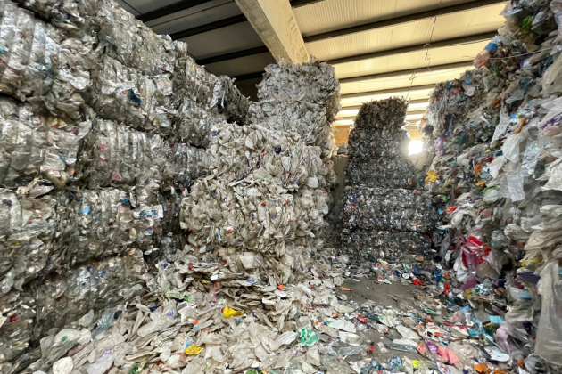 Plastic bales are stacked on top of each other to ceiling height 