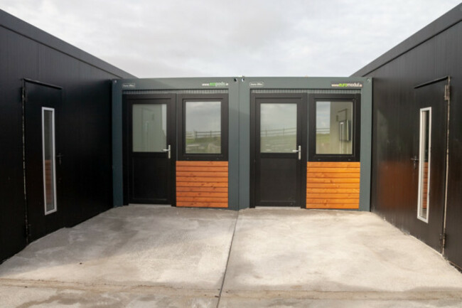 Black portacabins with doors and blue sky