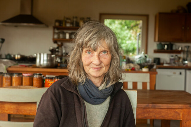 Ciara Cullen in a grey jumper sitting at a table in her kitchen