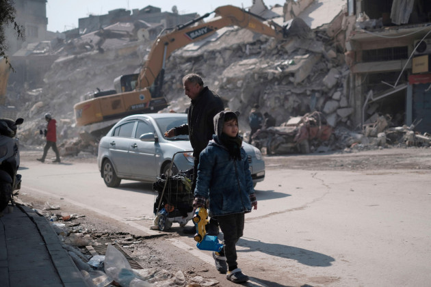 a-boy-walks-near-collapsed-buildings-in-antakya-southernmost-turkey-on-february-13-2023-the-devastating-earthquake-occurred-in-southern-turkey-and-syria-on-february-6th-and-more-than-33000-people