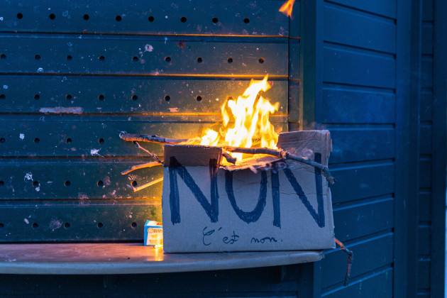 paris-france-20th-mar-2023-a-burning-placard-seen-during-the-protest-hundreds-of-people-gathered-in-place-vauban-in-paris-for-another-wave-of-protests-after-macron-forced-the-reform-of-pensions