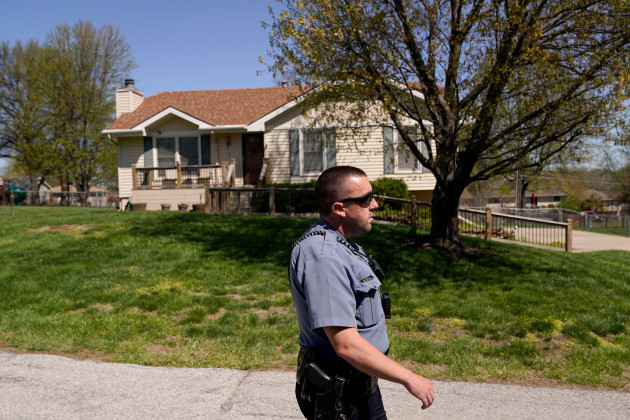 a-police-officer-walks-past-the-house-monday-april-17-2023-where-16-year-old-ralph-yarl-was-shot-thursday-when-he-went-to-the-wrong-address-to-pick-up-his-younger-brothers-in-kansas-city-mo-ap-p